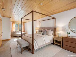 Step into luxury with this stunning bedroom featuring a beautiful wooden ceiling and a grand four-poster bed.