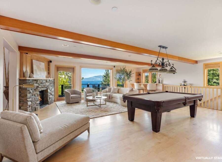 This stunning property boasts a luxurious living space with a cozy fireplace and a relaxing chaise lounge.