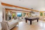 This stunning property boasts a luxurious living space with a cozy fireplace and a relaxing chaise lounge.