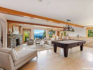 This stunning property boasts a luxurious living space with a cozy fireplace and a relaxing chaise lounge.