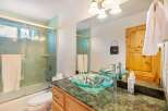 Step into a beautifully designed bathroom featuring a stylish glass vessel sink and a luxurious green granite countertop.