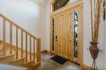 Step into luxury with this stunning entryway! Featuring a beautiful wooden door with intricate glass detailing, this space exudes warmth and elegance.