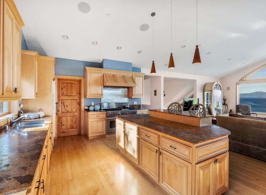 This stunning kitchen boasts custom cabinetry, a large island, and high-end appliances, perfect for culinary enthusiasts.