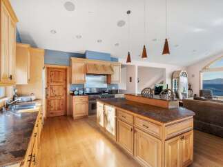 This stunning kitchen boasts custom cabinetry, a large island, and high-end appliances, perfect for culinary enthusiasts.
