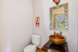 This stunning bathroom features a unique gold-toned sink and a stylish mirror, creating a luxurious and inviting space.