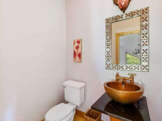 This stunning bathroom features a unique gold-toned sink and a stylish mirror, creating a luxurious and inviting space.