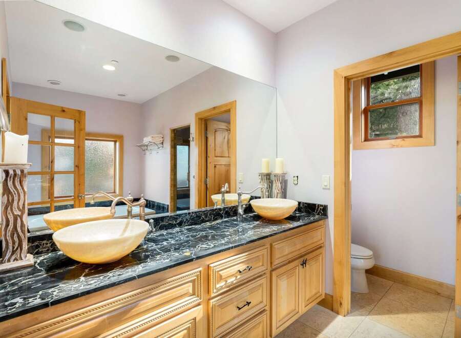 This luxurious bathroom features a stunning black marble countertop with dual sinks, offering ample space and elegance.