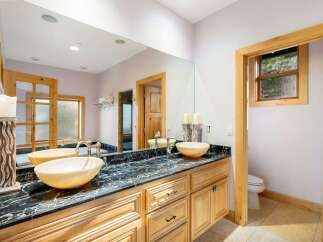 This luxurious bathroom features a stunning black marble countertop with dual sinks, offering ample space and elegance.