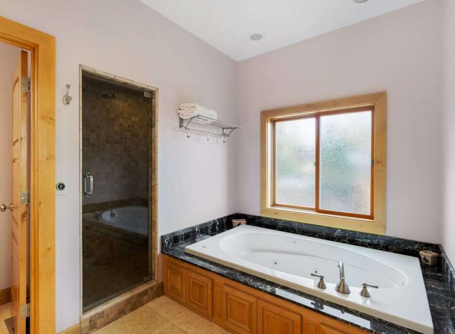 Indulge in luxury within this stunning bathroom, featuring a spacious jacuzzi tub perfect for relaxation.
