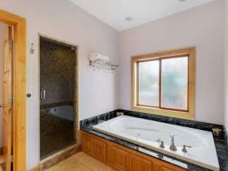 Indulge in luxury within this stunning bathroom, featuring a spacious jacuzzi tub perfect for relaxation.