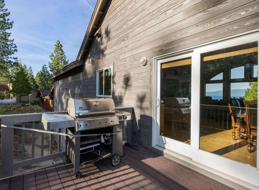 Enjoy outdoor living at its finest with this stunning property featuring a spacious deck and a high-end Weber grill, perfect for entertaining.