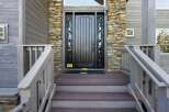 This stunning property boasts a beautifully crafted entrance, featuring a dark wooden door complemented by stone accents.