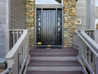 This stunning property boasts a beautifully crafted entrance, featuring a dark wooden door complemented by stone accents.