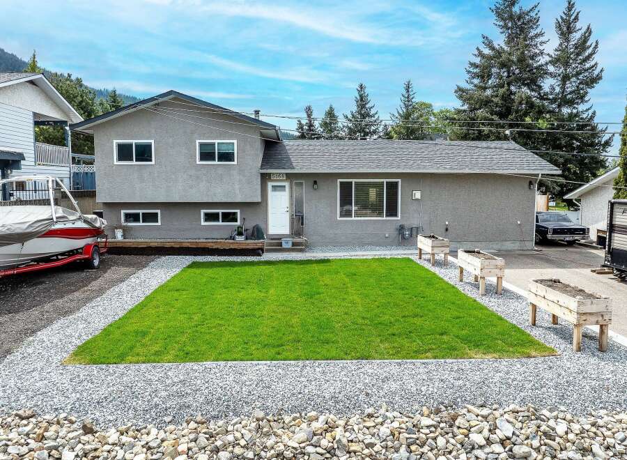 This charming property boasts a well-maintained exterior with a lush green lawn, perfect for outdoor enjoyment.