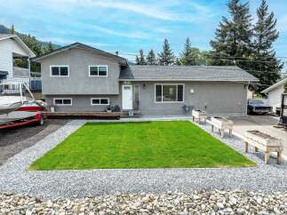 This charming property boasts a well-maintained exterior with a lush green lawn, perfect for outdoor enjoyment.