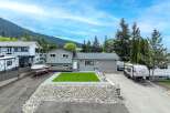 This stunning property boasts a beautifully landscaped yard with a lush green lawn and a rock garden.