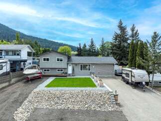 This stunning property boasts a beautifully landscaped yard with a lush green lawn and a rock garden.