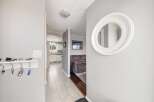 Step into this inviting entryway, showcasing a stylish round mirror and a convenient key holder.