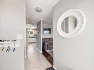 Step into this inviting entryway, showcasing a stylish round mirror and a convenient key holder.