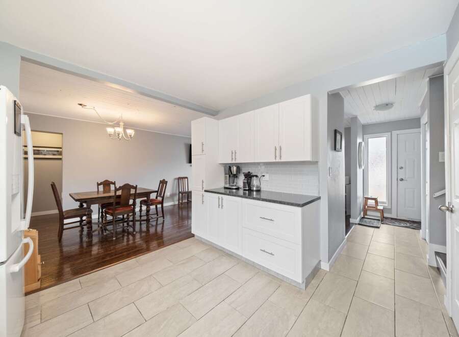 This stunning property boasts a bright and airy kitchen with modern white cabinetry and sleek countertops.