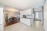 This stunning property boasts a bright and airy kitchen with modern white cabinetry and sleek countertops.