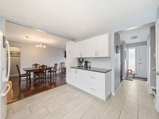 This stunning property boasts a bright and airy kitchen with modern white cabinetry and sleek countertops.