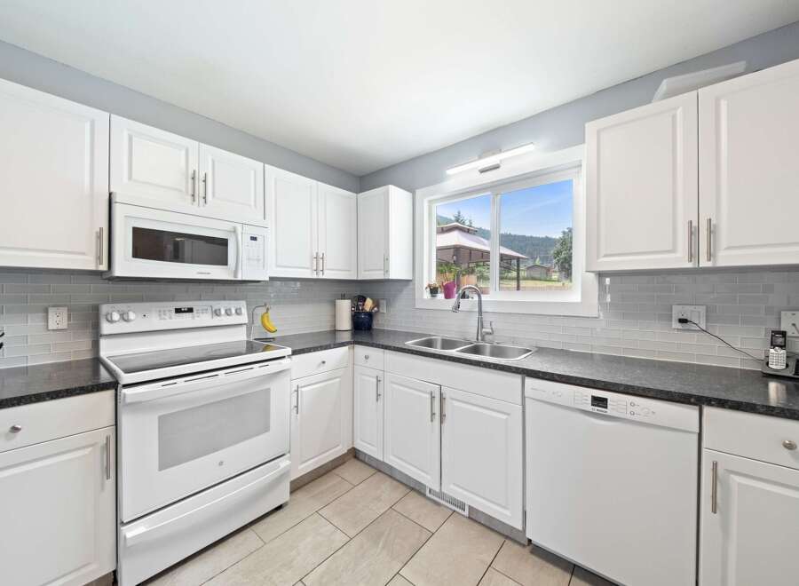 This bright and airy kitchen boasts pristine white cabinetry, offering ample storage and a clean aesthetic.