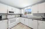 This bright and airy kitchen boasts pristine white cabinetry, offering ample storage and a clean aesthetic.