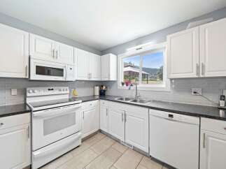 This bright and airy kitchen boasts pristine white cabinetry, offering ample storage and a clean aesthetic.