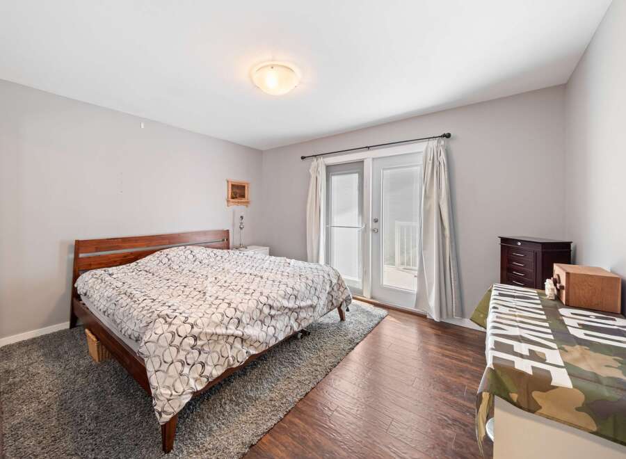 This inviting bedroom features a cozy bed with a stylish patterned comforter, perfect for a relaxing retreat.