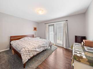 This inviting bedroom features a cozy bed with a stylish patterned comforter, perfect for a relaxing retreat.