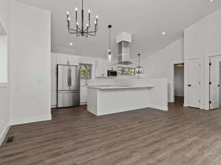 This stunning modern kitchen boasts sleek white cabinetry, stainless steel appliances, and a spacious island perfect for entertaining.