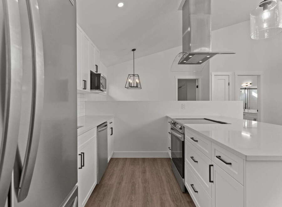 This stunning kitchen boasts modern design with sleek white cabinetry and stainless steel appliances.