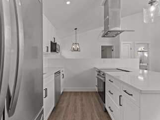 This stunning kitchen boasts modern design with sleek white cabinetry and stainless steel appliances.