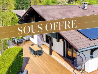 This charming property features a spacious wooden deck perfect for outdoor entertaining, complete with a dining set and lounge area.