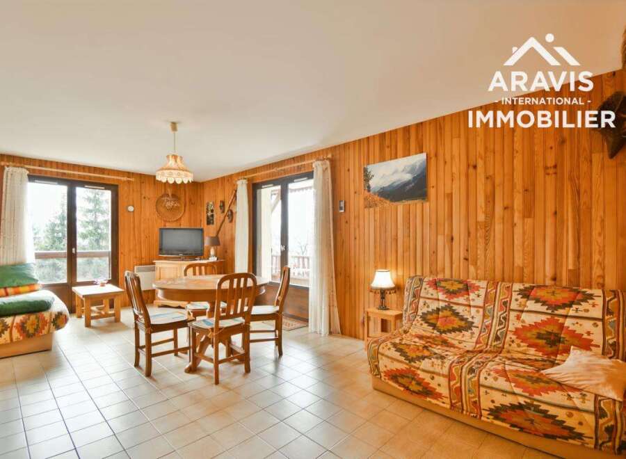 Discover this charming property featuring a cozy living space with wooden paneling and a comfortable sofa.