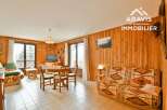 Discover this charming property featuring a cozy living space with wooden paneling and a comfortable sofa.