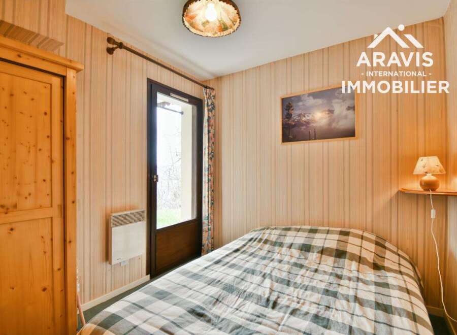 Discover this charming bedroom featuring a cozy bed with a checkered pattern, perfect for a relaxing retreat.