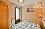 Discover this charming bedroom featuring a cozy bed with a checkered pattern, perfect for a relaxing retreat.