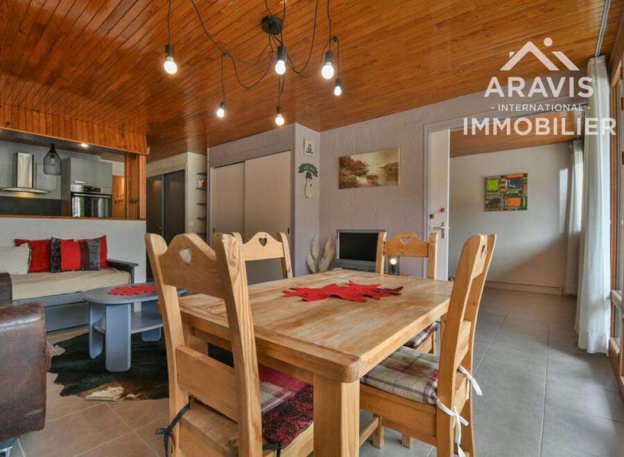Discover this charming property featuring a cozy dining area with a wooden table and chairs, perfect for family gatherings.