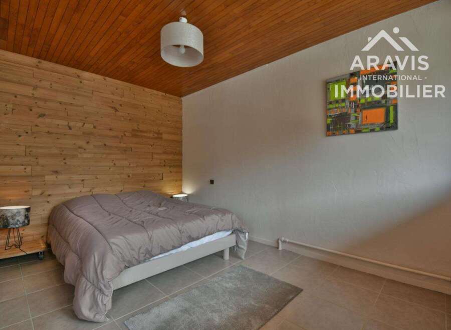 Discover the charm of this cozy bedroom featuring a unique wooden accent wall and ceiling.