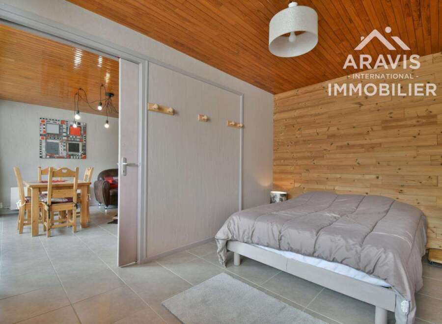 Discover this charming property featuring a cozy bedroom with a wooden accent wall and a comfortable bed.