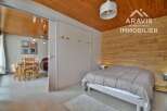 Discover this charming property featuring a cozy bedroom with a wooden accent wall and a comfortable bed.
