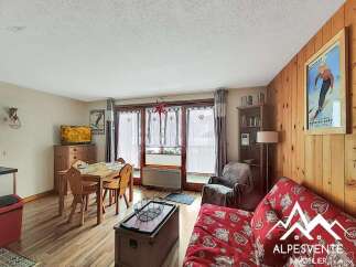 This charming living space features a cozy dining area with a wooden table and chairs, perfect for intimate meals.