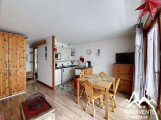 Charming alpine apartment featuring a cozy dining area with a wooden table and chairs, perfect for family meals.