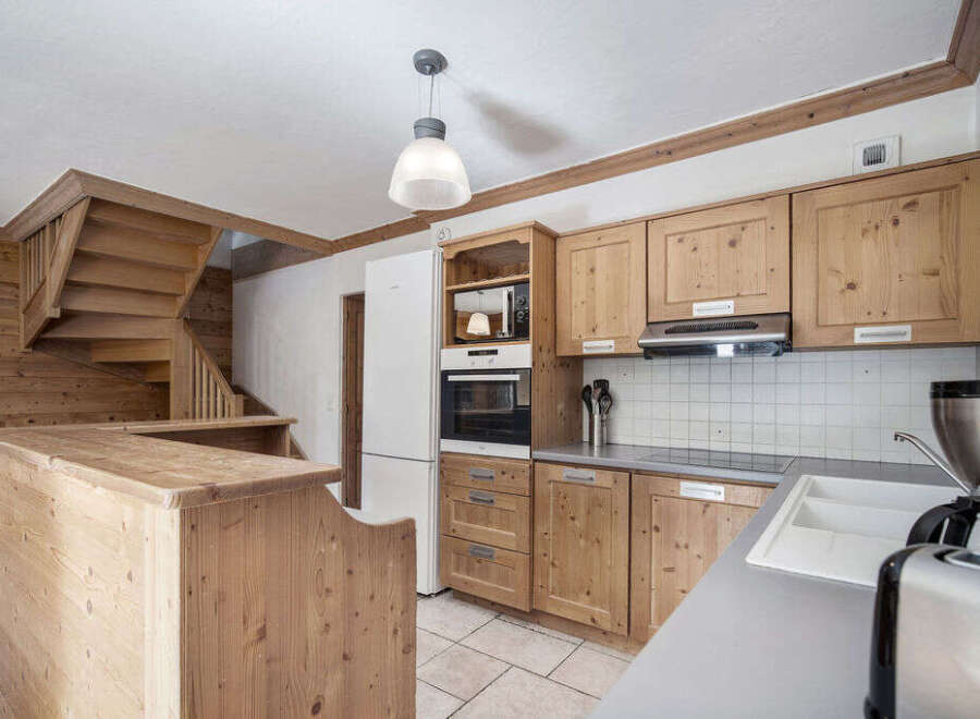 This charming kitchen boasts a rustic design with wooden cabinetry and a cozy atmosphere.