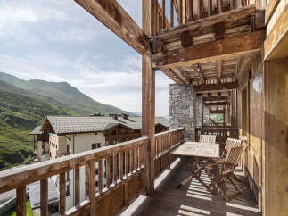 Experience the charm of this stunning property with its inviting balcony, offering breathtaking views of the surrounding mountains.