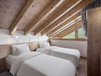 Discover the charm of this cozy bedroom featuring two comfortable beds, perfect for a relaxing stay.