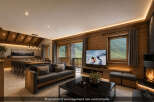 Experience luxurious mountain living in this stunning chalet-style living room, featuring a spacious dining area and a cozy seating arrangement perfect for relaxation.