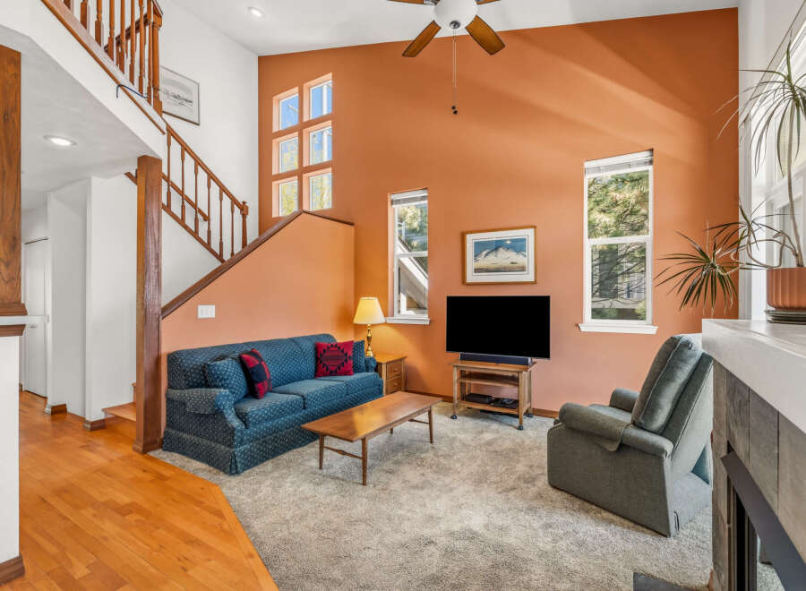 This inviting living room boasts a cozy ambiance with its plush blue sofa and a comfortable recliner, perfect for relaxing.